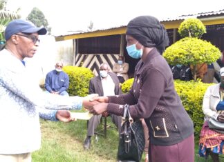 Don urges schools to be to lenient on fees Prof. Reuben Marwanga hands over a school fees cheque to one of the beneficiary's parent at Nyansiongo town Wednesday. PHOTO/Dan Nyamanga.