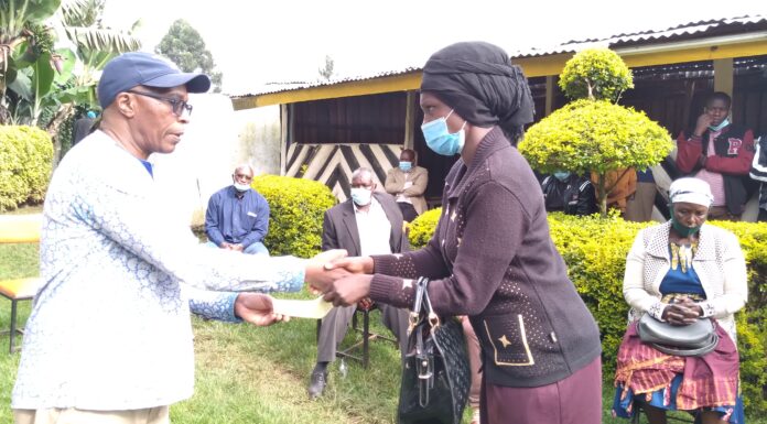 Don urges schools to be to lenient on fees Prof. Reuben Marwanga hands over a school fees cheque to one of the beneficiary's parent at Nyansiongo town Wednesday. PHOTO/Dan Nyamanga.