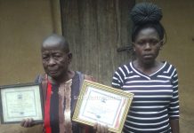 Agnes Kundu, a Traditional Birth Attendant (TBA), showcasing her certificates. Alongside her is one of her clients. PHOTO/Gilbert Ochieng, Scholar Media Africa.