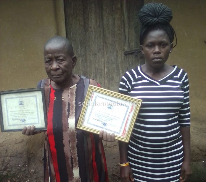 Agnes Kundu, a Traditional Birth Attendant (TBA), showcasing her certificates. Alongside her is one of her clients. PHOTO/Gilbert Ochieng, Scholar Media Africa.