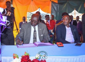 Baringo-based hospital to reap big for rescuing President Salva Kiir Barnabas Benjamin, Minister for Presidential Affairs of the Republic of South Sudan, signing the visitors book after leading a delegation to visit the health facility for rescuing President Salva Kiir's life three decades ago. Beside him is Felix Kimwok Baringo County Deputy Governor. PHOTO/Mercy Mission Hospital (MMH).