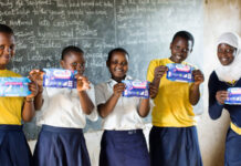 School-girls holding sanitary pads in a classroom. As the world celebrates World Menstrual Hygiene Day on May 28, 2023, statistics show that in Africa, 1 in every 3 women cannot afford sanitary products. Destigmatizing menstrual health and providing girls and women with menstrual products is timely and vital. PHOTO/Courtesy.