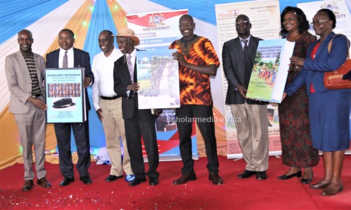 From left: Dr. Peter Mose, Prof. John Akama, Dr. Evans Mecha, Mzee Peter Getenga, Dr. Peter Otieno, Prof. Nicolas Makana, Dr. Marion Onyambu and Dr. Prisca Tanui hold their two books and a dictionary during the launch on May 31, 2023 at Kisii University. PHOTO/Boaz Khuteka, Scholar Media Africa.