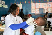 A health specialist attends to a pupil in Zambia as efforts to combat the ongoing cholera outbreak gain weight. The government, with support from WHO, has embarked on administration of vaccines in order to contain the crisis. PHOTO/MSF.